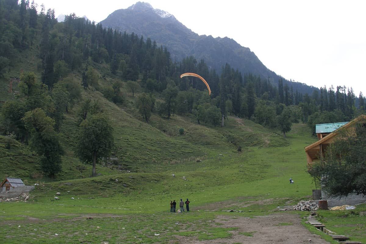 Paraglider above the green slopes of Solang Valley near Manali